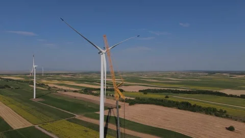 Wind turbine installation using a large construction crane. The assembly process Stock Footage 312734909