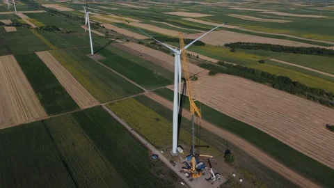 Wind turbine installation using a large construction crane. The assembly process Stock Footage 312735677