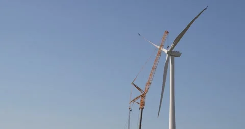 Wind turbine installation using a large construction crane. The assembly process Stock Footage 312736967