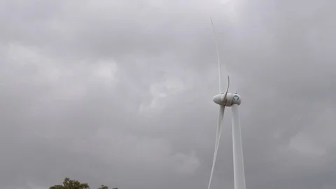 Wind turbine with its propeller rotating against cloudy sky Stock Footage 93140605