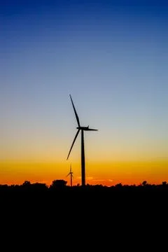 Wind turbine outline on red and blue sky. Foto stock