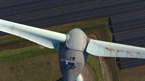 Wind turbine propeller rotating above solar panels Stock Footage 332850616