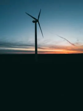 Wind turbine with rays of light at sunset. Stock Photos