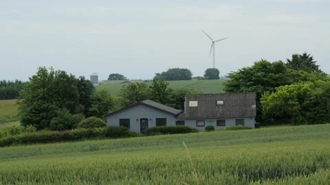 Wind turbine rotating over a house in the green countryside Stock Footage 338070909