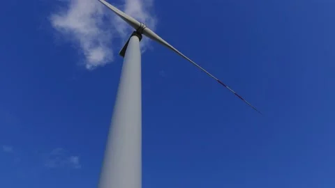 Wind turbine rotating slowly in the background of deep blue sky. Stock Footage 219998014