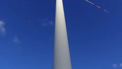 Wind turbine rotating slowly in the background of deep blue sky. Stock Footage 219998048