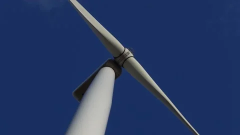 Wind turbine rotating slowly in the background of deep blue sky. Stock Footage 219998095
