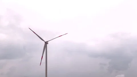 Wind turbine rotating under cloudy sky Stock Footage 308885733