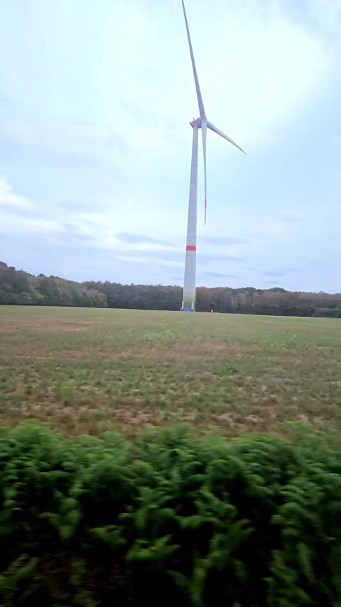 Wind Turbine Rotation in Open Field from Moving Train Window Stock Footage 344704946