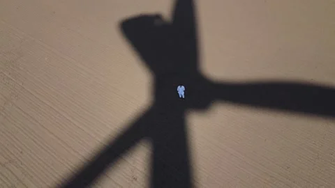 Wind Turbine Shadow On Open Grass Field Generating Green Energy. A man in white Stock Footage 151685096