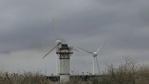 Wind turbine with a smoking chimney Stock Footage