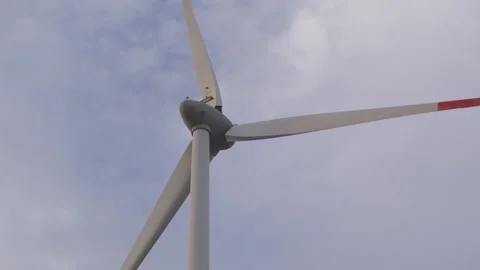 Wind turbine spinning in a clear sky at a renewable energy site Video stock 312242548
