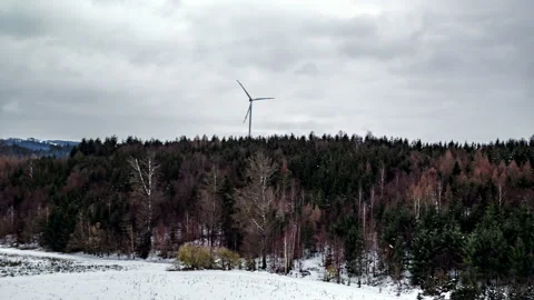 Wind turbine spinning in front of forest in winter 3 Stock Footage 147307597