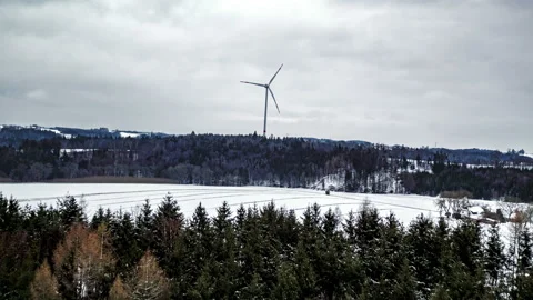 Wind turbine spinning in front of forest in winter 5 Stock Footage 147316980