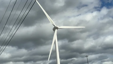 Wind Turbine Spinning Under Cloudy Skies in a Rural Area Stock Footage 317632387