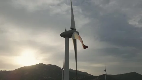 Wind turbine spinning under dramatic skies at sunset in the countryside Stock Footage 309426242
