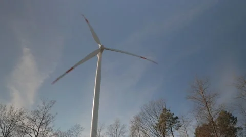 Wind Turbine spinning in Winter, with leafless trees UHD 4k Stock Footage 45439440