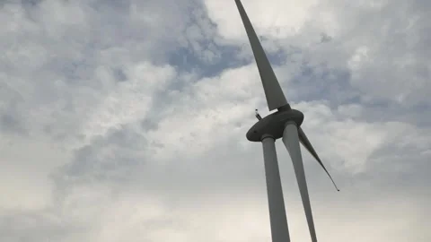 Wind turbine spins under cloudy sky near renewable energy site Stock Footage 309426122