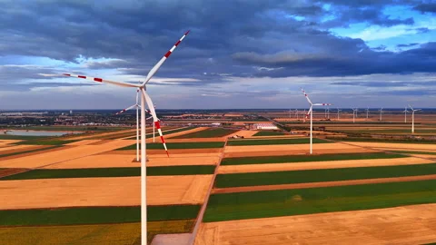 Wind turbine standing in multi colored agricultural fields. Close aerial view of Stock Footage 339015755