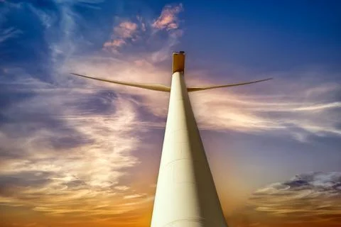 Wind turbine at sunset with dramatic sky. Stock Photos