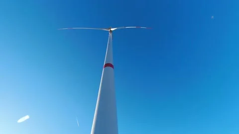 A wind turbine timelapse turning in front of a sunny sky Stockbeeldmateriaal 171318054