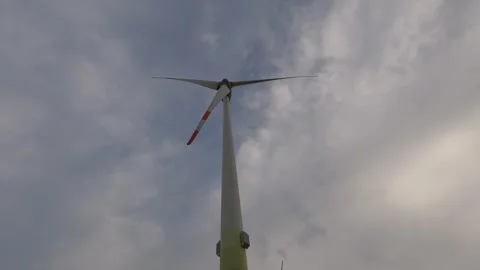 Wind turbine towering against cloudy sky in renewable energy hub Video stock 308024967