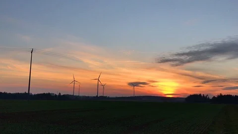 Wind turbine turning in front of sunset on field Stock Footage 118526653