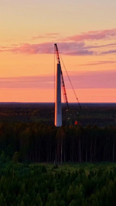 A wind turbine under construction in forest area on a sunset background. Stock Footage 337702632