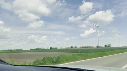 Wind Turbine Viewed from Car Window Under Dramatic Cloudy Sky Vídeos de archivo 335226299