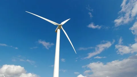 Wind turbine windmill with blades producing clean alternative renewable energy Stock Footage 163276074