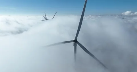 Wind turbines above the clouds, blue sky, white clouds. Renewable energy. Stock Footage 303474046