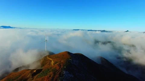 Wind turbines above the clouds on a mountain peak generating clean energy Stock Footage 311819828