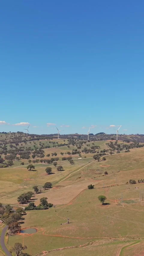 Wind turbines across rolling countryside hills in regional Australia Stock Footage 335001853