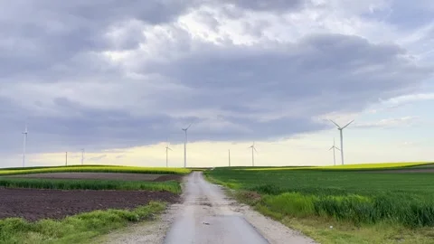 Wind Turbines on Agricultural Fields Under Dramatic Evening Sky Video stock 335215379