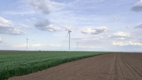 Wind Turbines on Agricultural Fields Under Dramatic Evening Sky Video stock 335215406