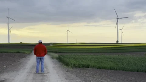 Wind Turbines on Agricultural Fields Under Dramatic Evening Sky Video stock 335215722