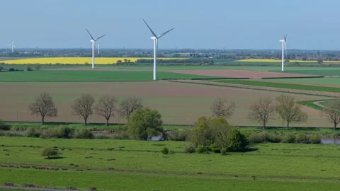 Wind Turbines and Arable Crop Fields in Low Pan Aerial Drone Shot in UK Stock Footage 346140606