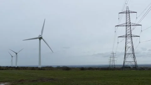 Wind Turbines and High Voltage Power Lines Across Rural Energy Infrastructure Stock Footage 336486778