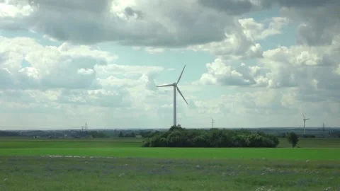 Wind turbines and open fields viewed from a moving train in slow motion 250fp Stock Footage 282338142
