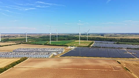 Wind turbines and solar panels in a rural area with fields and clear skies Stock Footage 342738682