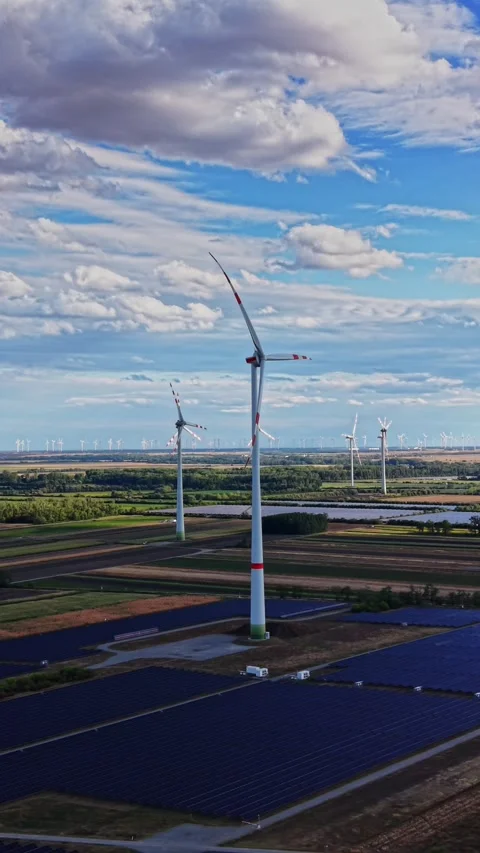 Wind turbines and solar panels in a large green field Stock Footage 344535627