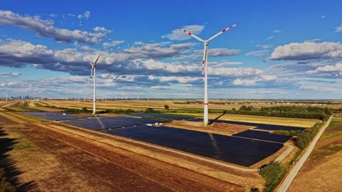 Wind turbines and solar panels working together in a renewable energy field Stock Footage 344536031