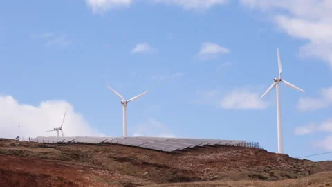 Wind turbines and solar panels generating clean renewable energy on a rugged Vidéo 345840330