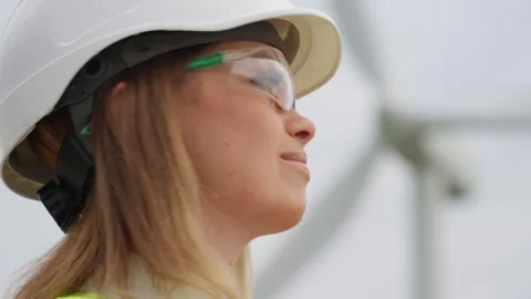 Wind turbines are the future of energy: a woman in a helmet and goggles Video stock 252133536