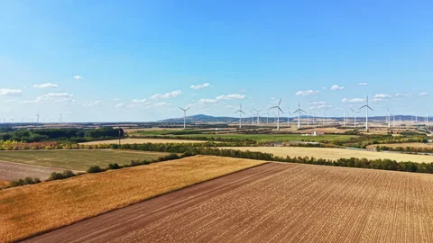 Wind turbines are turning in the fields during a sunny day in the countryside Stock Footage 342733121