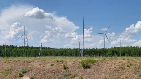 Wind turbines on the background of a blue sky and green field, natural energy. Stock Footage 287622820