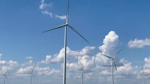 Wind turbines on the background of a blue sky and green field, natural energy. Stock Footage 287622861