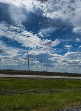 Wind Turbines Beneath a Dramatic Cloudy Sky in a Rural Landscape Foto stock