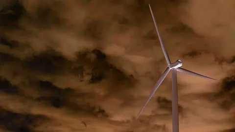 WIND TURBINES with blades move slowly in a field of brown sky covered with Stock Footage 208643449