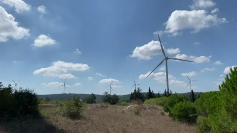 Wind turbines, cloudy blue sky silhouette and trees Stock Footage 138884581